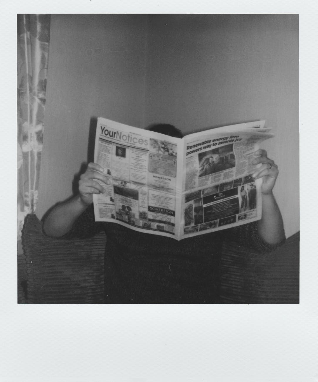grayscale photography of man reading newspaper